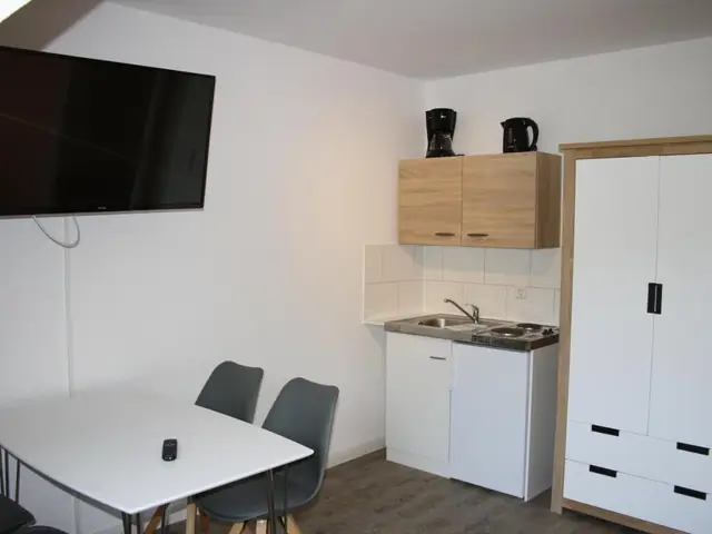 Küche des Apartments mit Tisch und zwei Stühlen