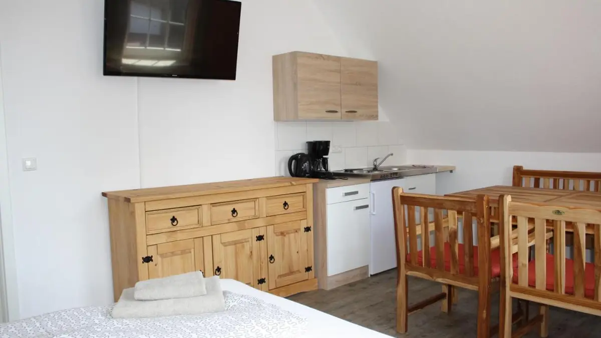 Essbereich mit Holztisch und Anrichte neben der Küche