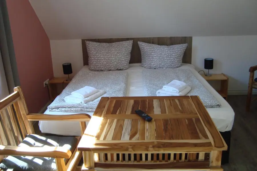 Schlafzimmer eines Apartments im Apartmenthaus Muschelsucher, mit Doppelbett und Holztisch